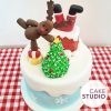 Bolo decorado de Natal: Papai Noel entalado na chaminé, árvore de Natal, rena, presentes e neve. Feito por Cake Studio ( contato@cakestudio.com.br )