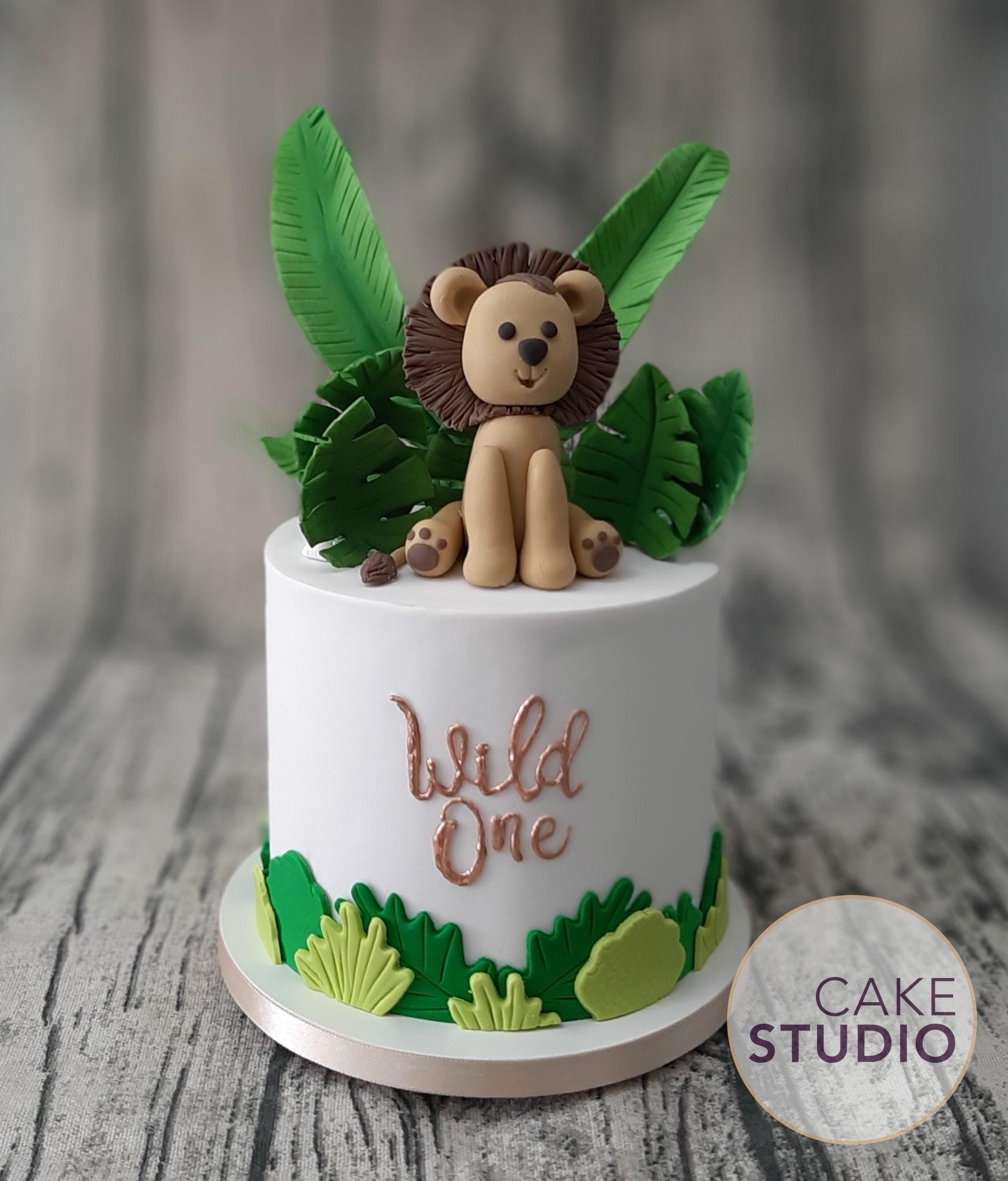Bolo Leão na Selva com folhagens e dizeres em cobre para festa safári elegante. Feito por Cake Studio ( contato@cakestudio.com.br | Whatsapp (11) 96882-2623 ).